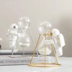 Astronaut figures with hourglasses and scientific decor items for educational and decorative purposes.