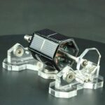 Solar-powered robot model with transparent parts and solar panel, showcasing renewable energy technology.