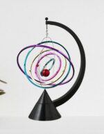Elegant planetary model with colorful orbits and a red sphere representing a planet, mounted on a black stand.