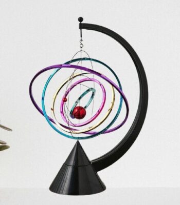 Elegant planetary model with colorful orbits and a red sphere representing a planet, mounted on a black stand.
