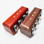 Two polished wooden dice towers, one in reddish-brown and the other in darker brown, designed for enhancing board game experiences and educational purposes.