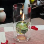 Glass container with a floating candle and liquid, demonstrating scientific principles of combustion and buoyancy.