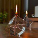 A glass cube with a lit candle inside, creating a mesmerizing visual effect.
