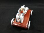 Magnetic levitation demonstration device with metal rings and a wooden base.