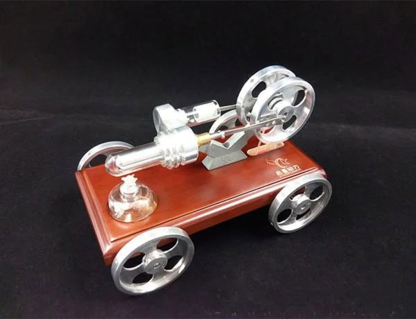 Small metallic Stirling engine model with a wooden base, demonstrating thermodynamic principles and mechanical motion for educational purposes.