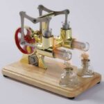 Small Stirling engine model with glass test tubes and wooden base, ideal for science experiments and educational demonstrations.