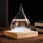 A glass flask with a narrow neck containing a bubbling chemical reaction, placed on a wooden base on a dark background.