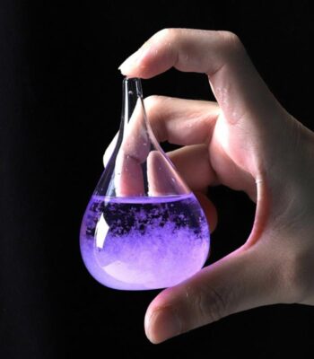 A hand holding a glass flask filled with purple liquid, showcasing a science experiment.