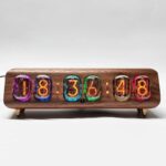 Vintage nixie tube clock displaying time with colorful glowing tubes on a wooden base, modern retro decor piece.