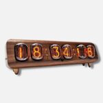 Vintage nixie tube clock displaying time with glowing orange digits on a wooden base.
