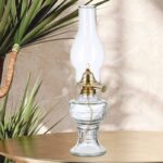 Vintage oil lamp with glass base and brass fittings, decorative lighting for home or educational displays.