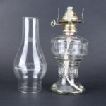 Clear glass vacuum chamber with metal lid and glass bottle, used for scientific experiments and demonstrations.