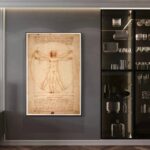 Classic Leonardo da Vinci Vitruvian Man drawing displayed on a wall, showcasing the famous anatomical sketch with detailed notes, in a modern interior setting.