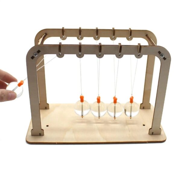 Pendulum science experiment with five glass balls and a wooden frame.