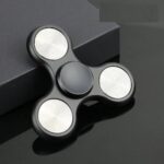 Modern black fidget spinner with illuminated white LED circles, designed for stress relief and focus enhancement.