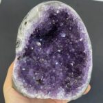 Close-up of a vibrant purple amethyst geode with sparkling crystals, showcasing natural mineral formations.