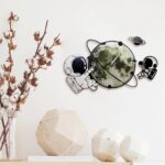 Space-themed wall clock with astronaut, planet, and moon illustrations, perfect for science and educational decor in kids' rooms or classrooms.