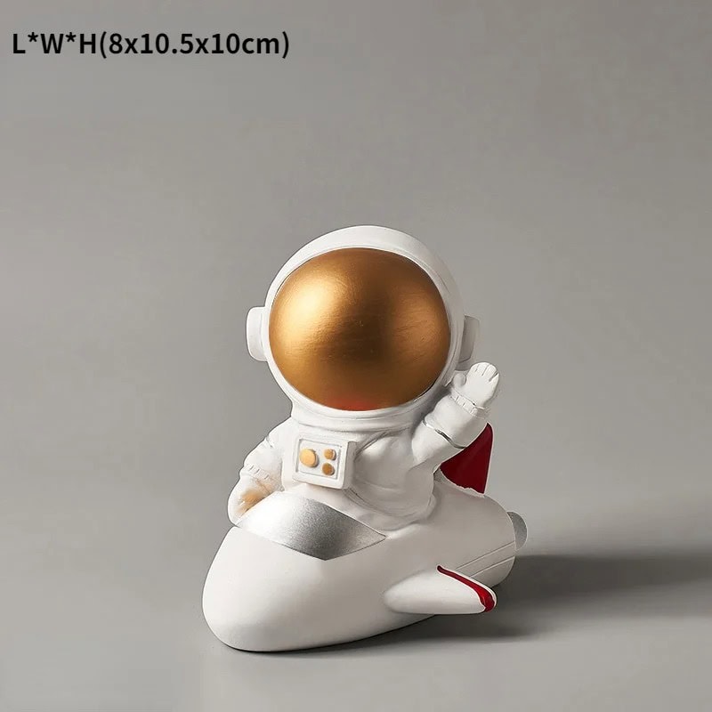 Science Gadgets | Science Decor & Educational Toys Shop A cute astronaut figurine with a gold helmet, sitting on a white rocket-shaped base, perfect for science-themed decor or educational purposes.