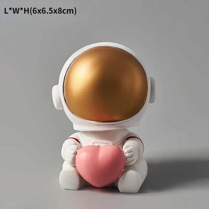 Cosmic Baby Astronaut Figurine with Heart Adorable astronaut figurine holding a pink heart, featuring a shiny gold helmet and white suit, perfect for science-themed decor or educational toys.