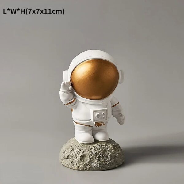 An adorable astronaut figurine with a gold reflective helmet, standing on a moon-like surface, perfect for science decor and educational displays.