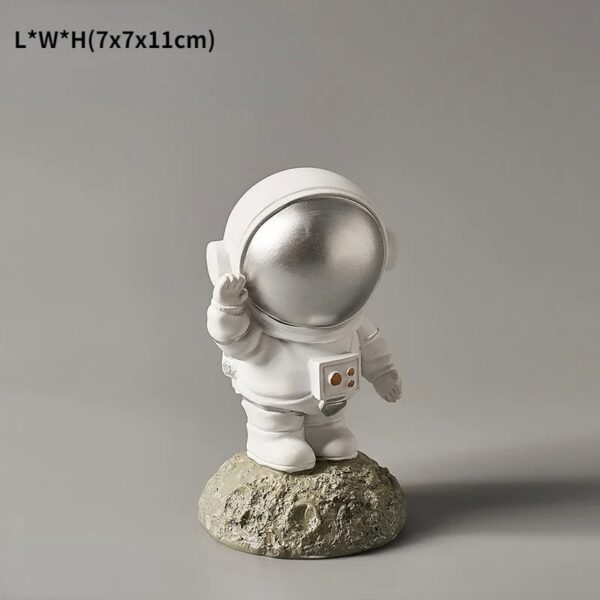 A cute astronaut figurine with a reflective helmet, standing on a textured moon-like base. Perfect for science decor or educational displays related to space exploration.