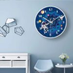 Colorful space-themed wall clock with astronaut and planets design, perfect for children's rooms or educational spaces.