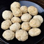 Close-up of multiple beige stone balls on a black plate, suitable for science experiments, decor, or educational toys.