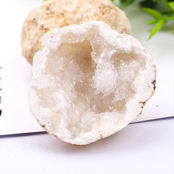 Close-up of a white geode mineral with crystalline interior, showcasing natural rock formation and textures.