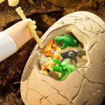 Dinosaur egg with miniature hatchlings inside, educational toy for kids to learn about prehistoric creatures and fossil discovery.