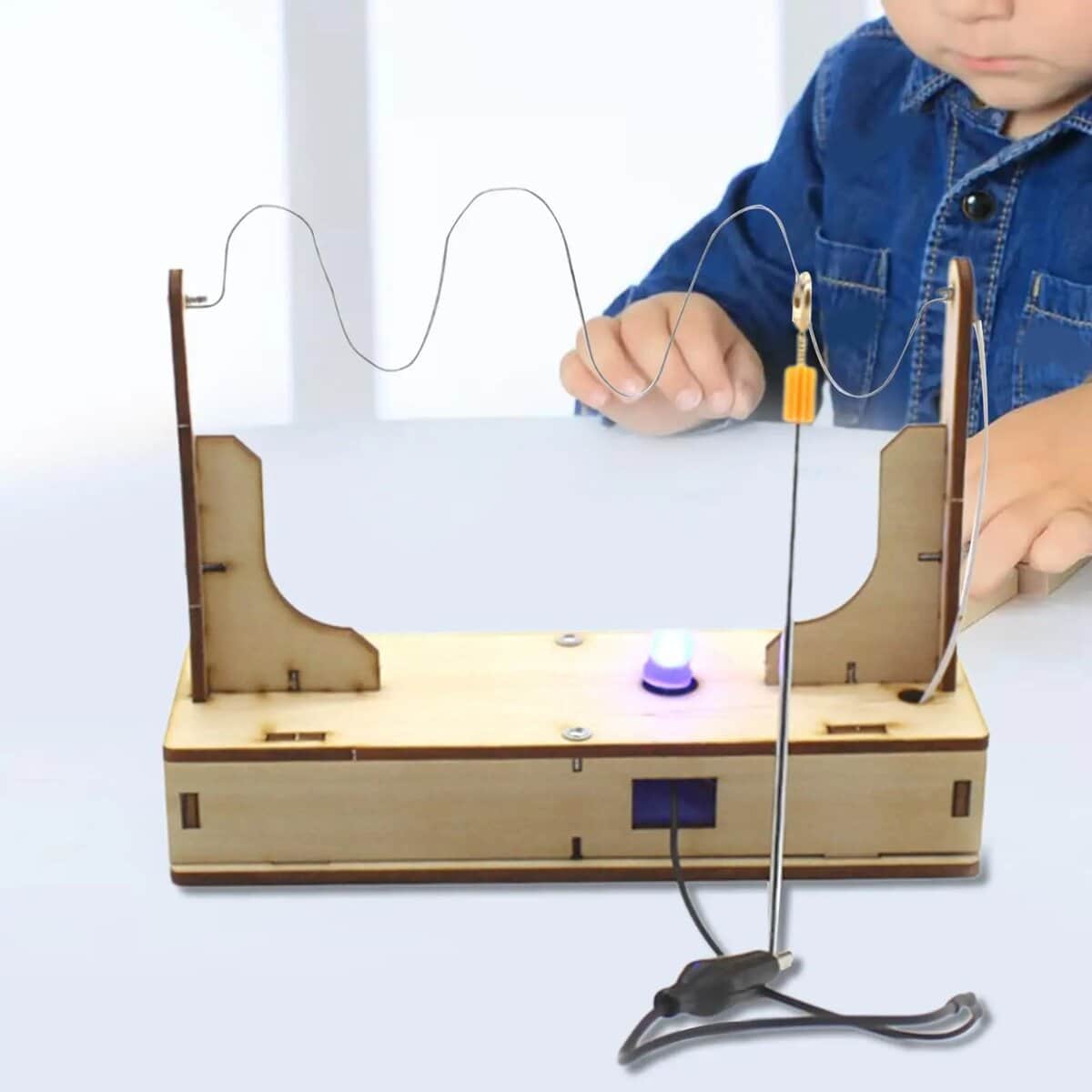 Magnetic Wave Experiment Kit Child conducting a magnetic wave experiment with a wooden wave generator and iron filings, demonstrating wave patterns and magnetic fields for educational purposes.