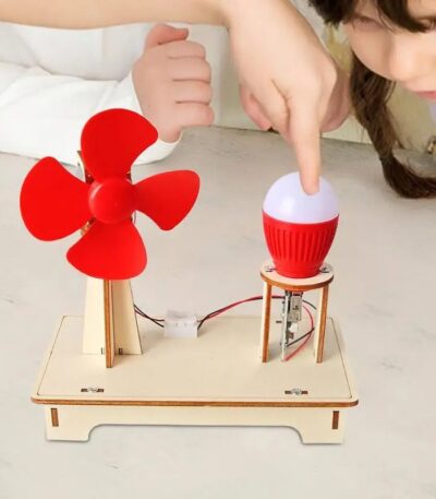 Child demonstrating a DIY wind turbine and light bulb experiment with a small red wind turbine and a light bulb on a wooden base, promoting renewable energy education.