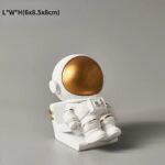 Astronaut figurine with a white suit and gold helmet, perfect for science-themed decor and educational purposes.