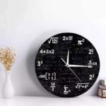 Modern wall clock with a black chalkboard design featuring white mathematical formulas and equations, perfect for science and math enthusiasts.