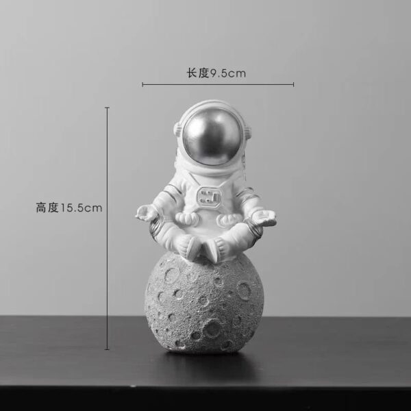Cute astronaut figurine sitting on a moon rock model.