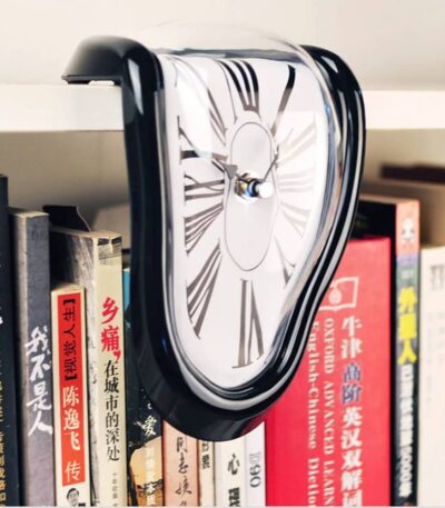 A melting clock sculpture inspired by Salvador Dalí's surrealist art, draped over a row of books on a shelf. The clock appears to be melting and distorted, creating a dreamlike and artistic visual.