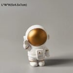 A cute astronaut figurine with a gold helmet, white suit, and detailed accessories, perfect for science-themed decor or educational displays.