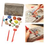 Children's gemstone excavation kit with tools and a stone block for digging and discovering colorful gemstones and minerals.