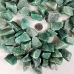 Collection of green fluorite crystal stones of various sizes, perfect for healing, decoration, or educational purposes, with a quarter for scale.