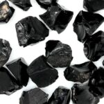 Collection of black obsidian stones showcasing their natural glossy surface and irregular shapes, used for healing, protection, and spiritual practices.
