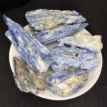 Collection of raw blue kyanite mineral specimens displayed on a white plate, ideal for educational purposes and scientific study.