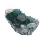 Close-up of a greenish-blue crystal mineral specimen with cubic formations on a white background.