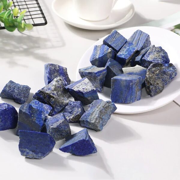 Natural lapis lazuli mineral stones with deep blue color and gold pyrite inclusions, displayed on a white surface for educational and decorative purposes.