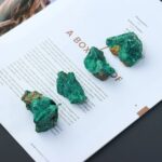 Malachite mineral specimens displayed on a magazine page, showcasing vibrant green crystalline formations perfect for educational purposes or decorative use.