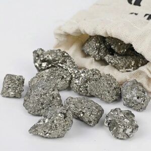 Close-up of metallic silver pyrite mineral rocks spilling from a cloth bag, showcasing their shiny, crystalline surface.