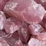 Close-up of pink rose quartz crystals showcasing their natural rough texture and soft pink hue, ideal for healing, meditation, or decorative purposes.