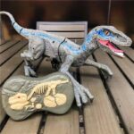 Realistic T-Rex dinosaur toy with detailed scales and vibrant colors, displayed on a wooden surface alongside a fossil replica for educational and decorative purposes.