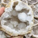 Close-up of a geode with sparkling white crystals inside, showcasing natural mineral formations and textures.