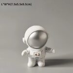 Adorable astronaut figurine with a silver helmet and white suit, perfect for science decor and educational toys. Compact size ideal for display or learning activities.