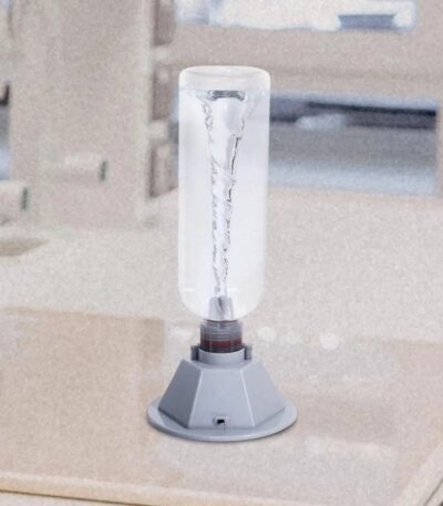 A science experiment setup showing a glass container with water and a metal electrode connected to a power source, demonstrating electrolysis.