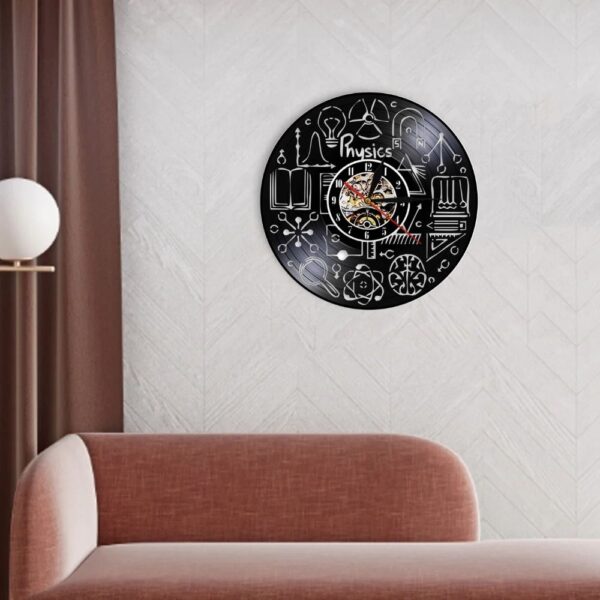 Physics-themed wall clock featuring scientific symbols and illustrations on a black background.